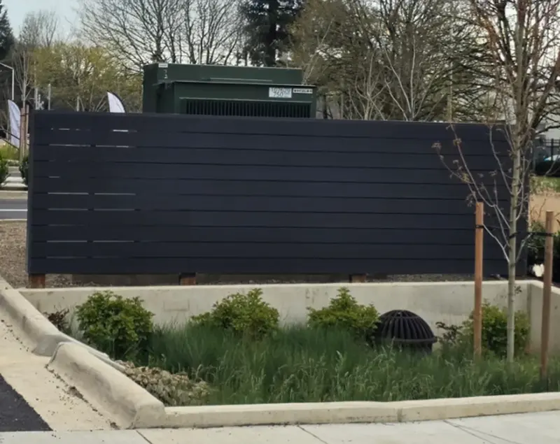 Modern horizontal-slat privacy fence screening equipment on a commercial site
